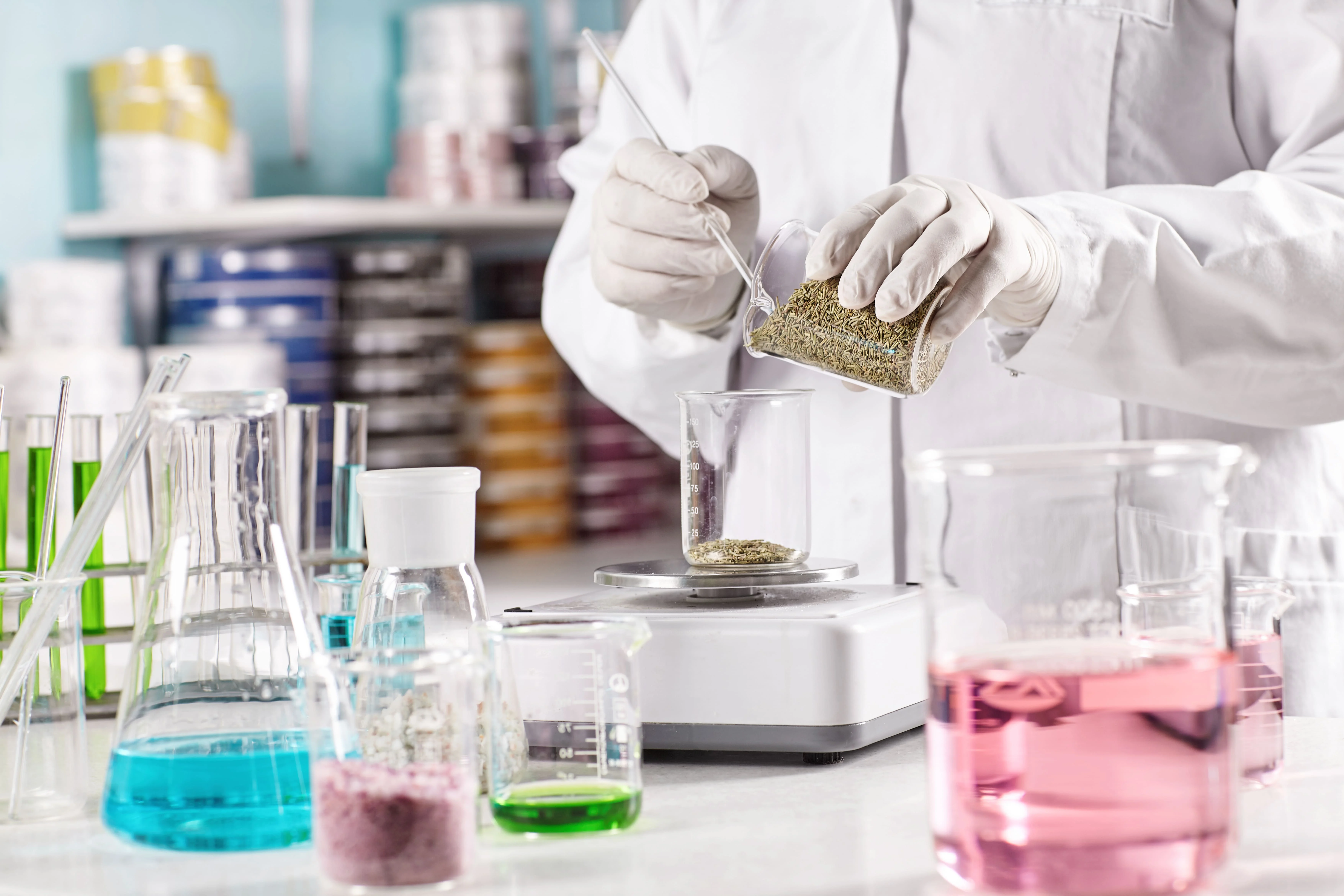 Worker Surrounded With Glass Beakers Filled With Colorful Liquid 1